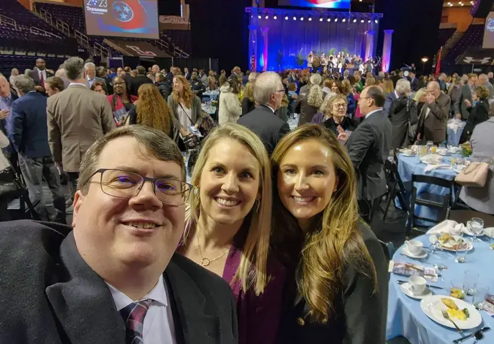 three people taking a selfie at a conference